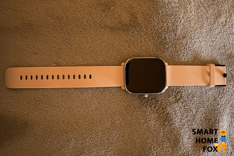 Die Amazfit GTS 2 Mini in oranger Farbe liegt auf einer Decke